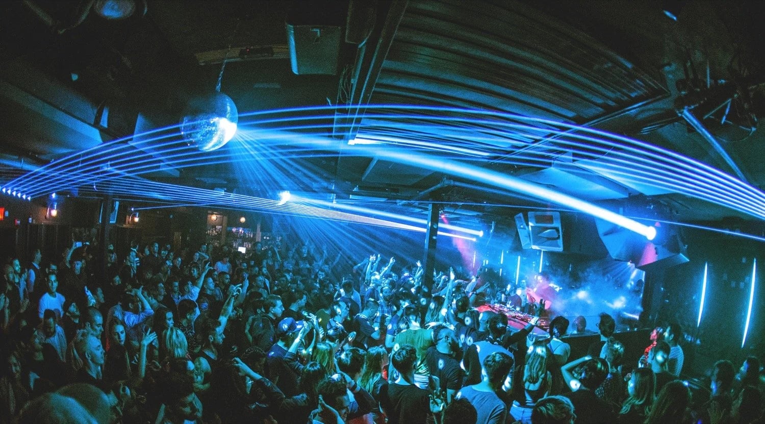 Dramatic club lighting with beams of light cutting through darkness